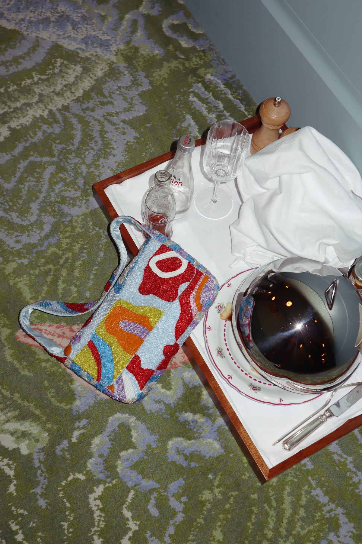 Rivers Run Deep Sky Zone beaded bag beside a room service tray