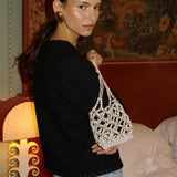 Sunday’s Best pearl and crystal bag worn with a black jacket and jeans
